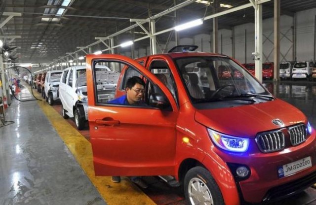 An employee assembles an electric car along a production line at a factory in Qingzhou
